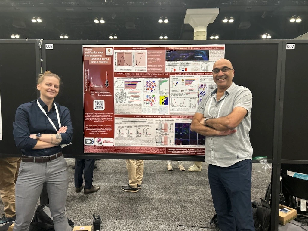 Dr. Avtar Roopra and his mentee, Olivia Hoffman, stand in triumphant positions in front of their poster at AES in 2024.