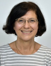 Dr. Annamaria Vezzani smiling in front of a grey background.
