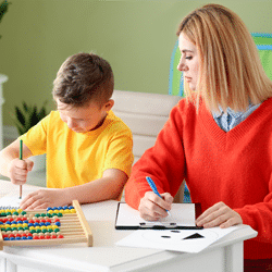 Female psychologist working with boy who has autism and epilepsy.
