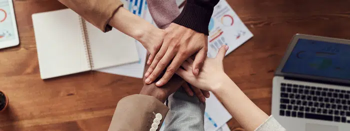 Hands stacked on top of each other during a huddle.