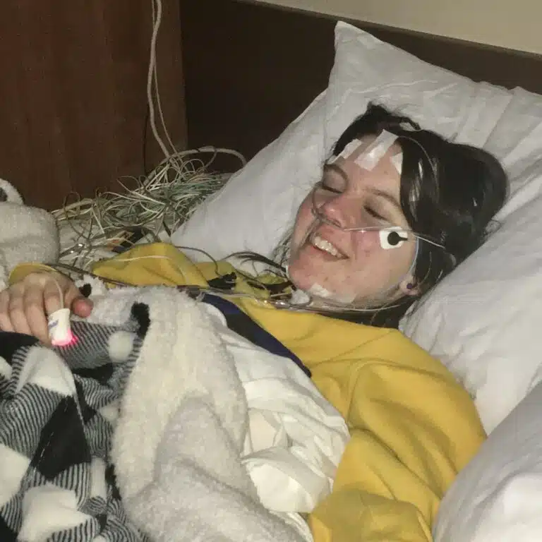Woman with epilepsy laying in hospital bed for an overnight EEG