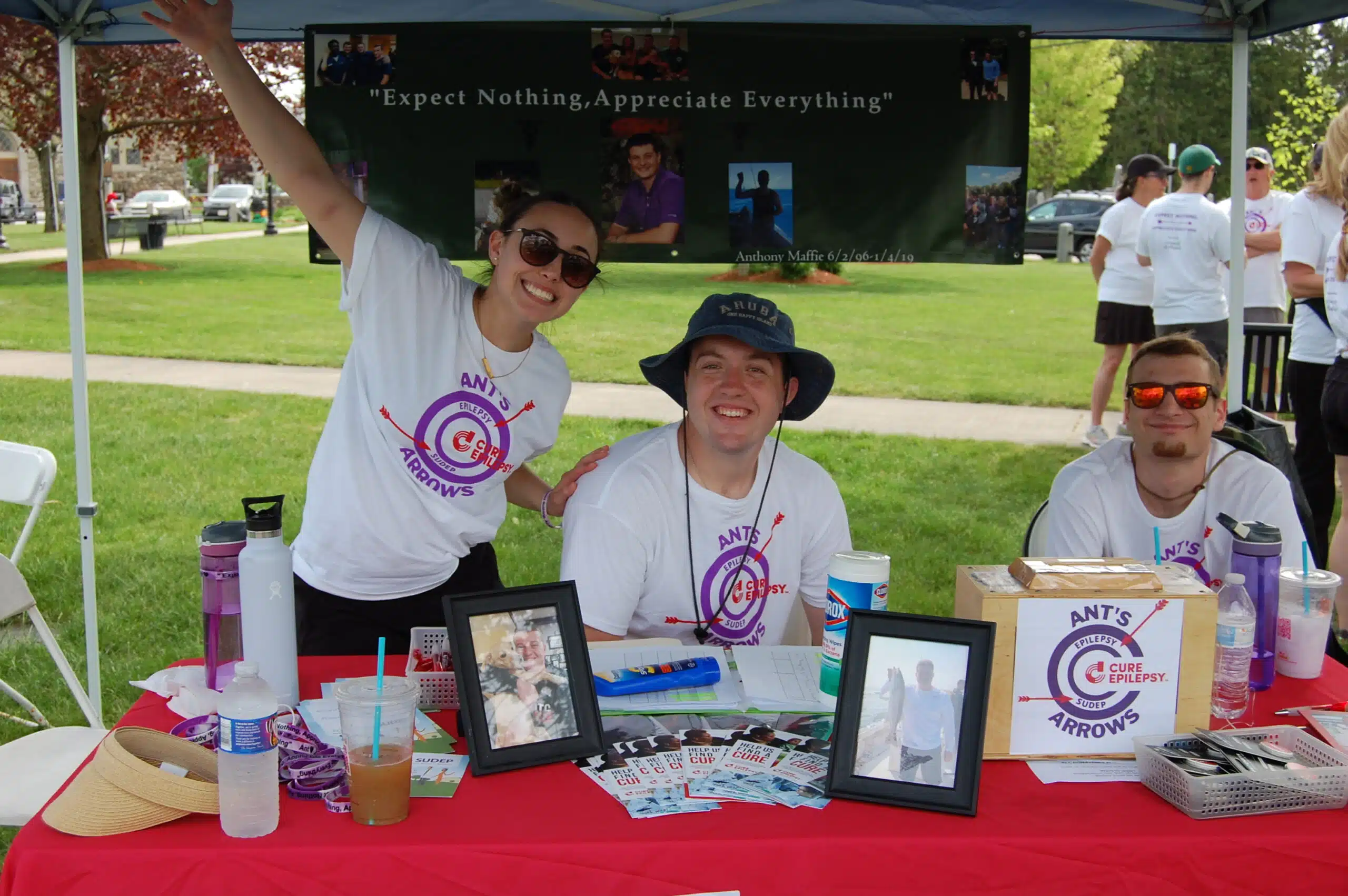 CURE Epilepsy advocates smiling for photo wearing merchandise outside at an event