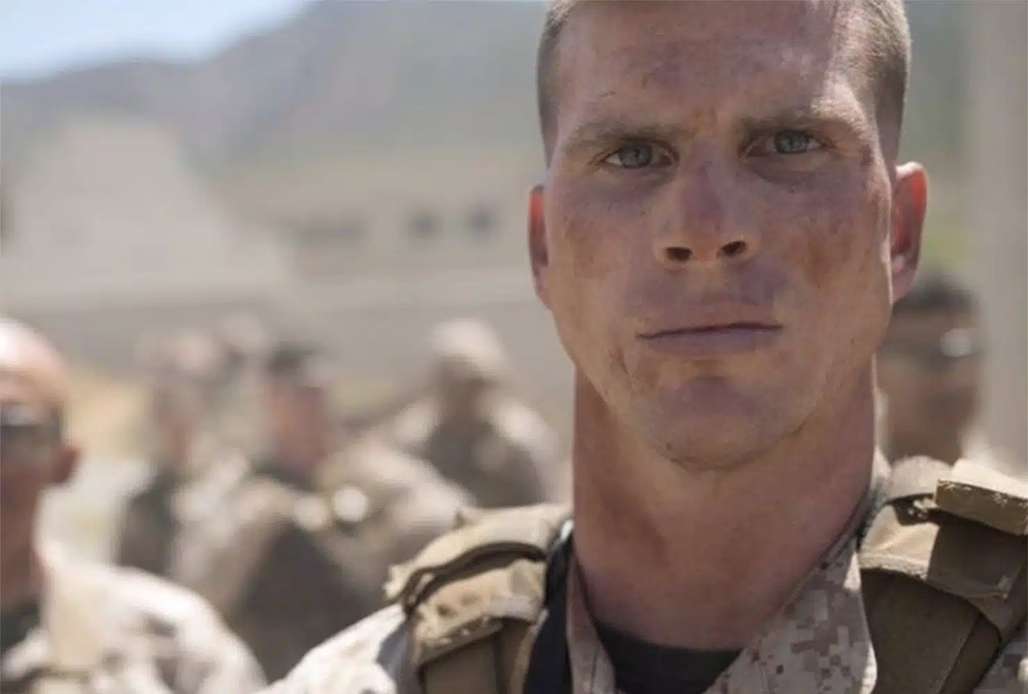 A closeup of a soldier's face standing at attention.