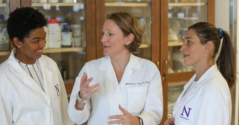 Three doctors wearing lab coats having a conversation about curing epilepsy in a hospital setting