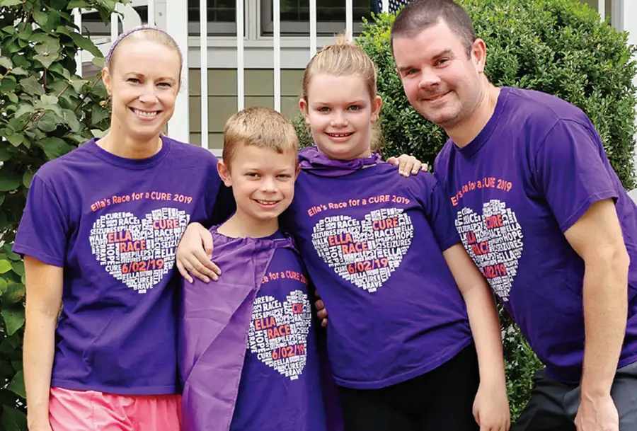 Photo of family smiling wearing purple for Ella's race event