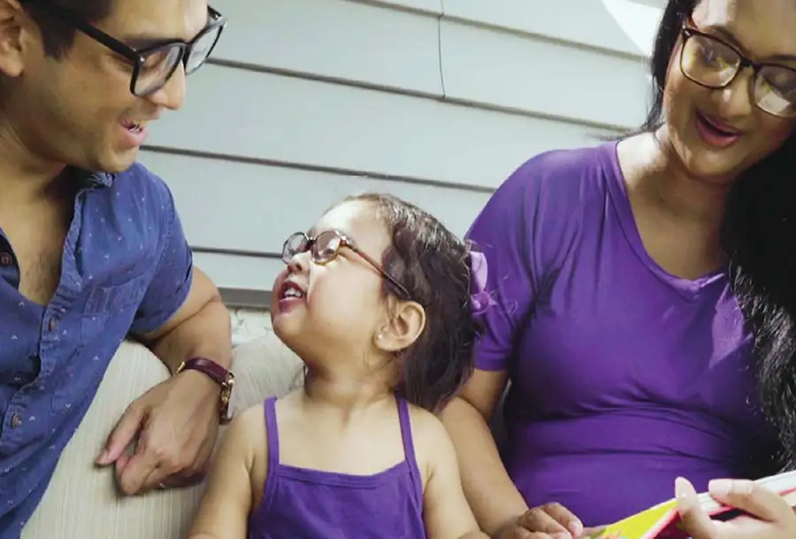 Photo of family wearing purple sitting together outside