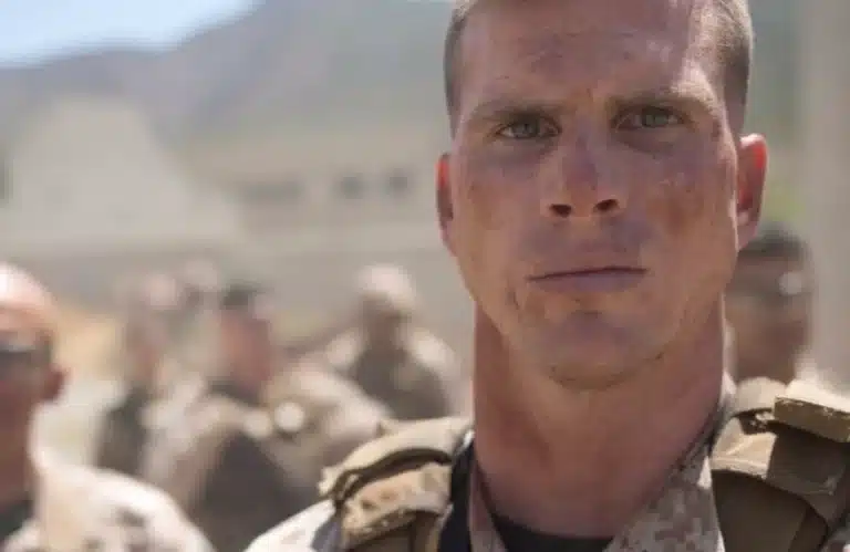 United States Marine Jack Somers stares ahead of him with a straight face wearing military uniform.