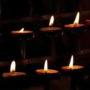 six candles lit in a dark room