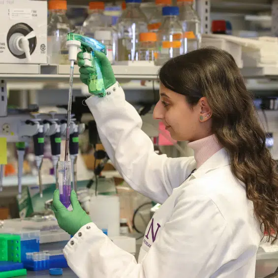 Woman in lab coat using lab tools for epilepsy research.