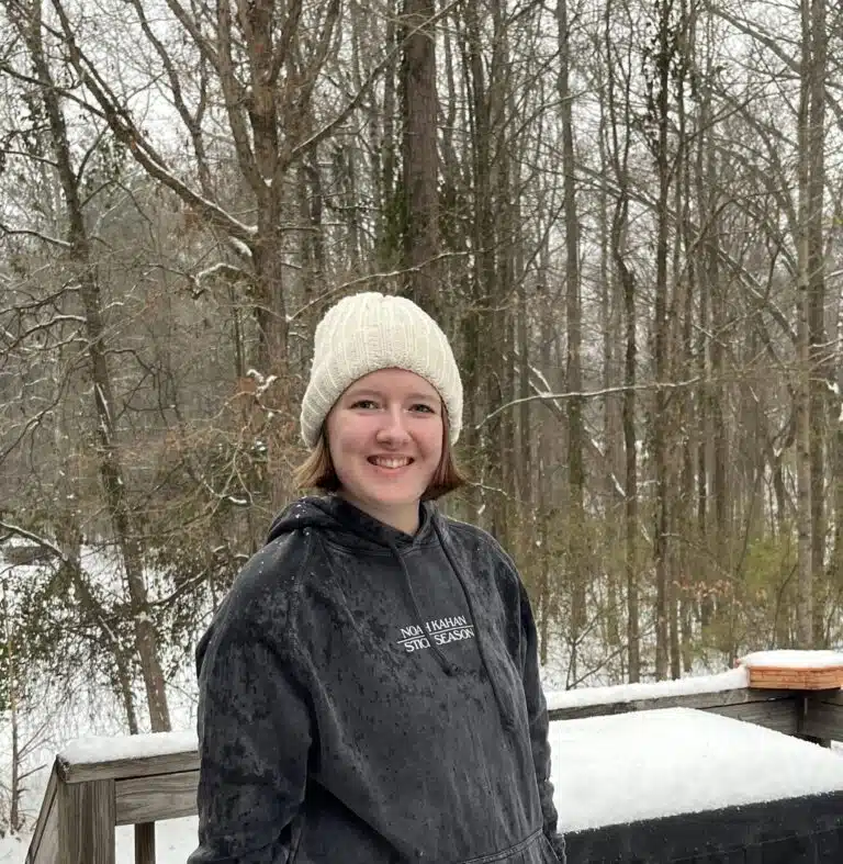 Woman with epilepsy, Olivia, standing smiling at camera