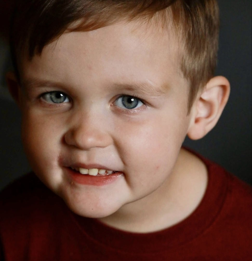 photo of young boy smiling up at camera