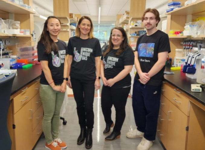 Dr. Mefford stands with three of the researchers in her lab. They're all wearing marching rare disorder t-shirts.